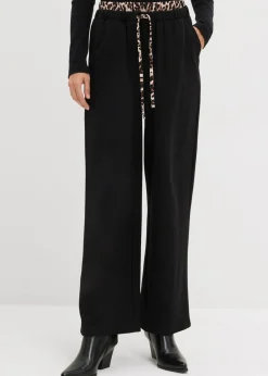 bonprix bonprix Pantalón de chándal ancho con cintura en contraste estampado leo negro Hot